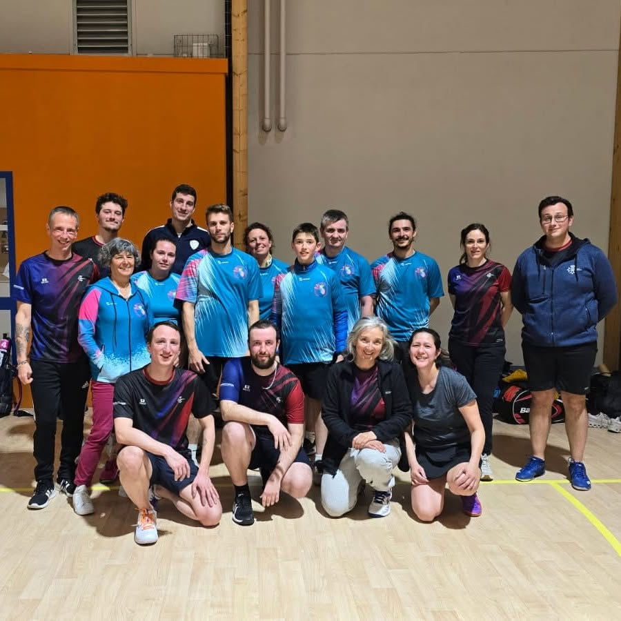 Un grand groupe de membres de Badaflo réuni dans un gymnase, plusieurs portant le maillot turquoise du club